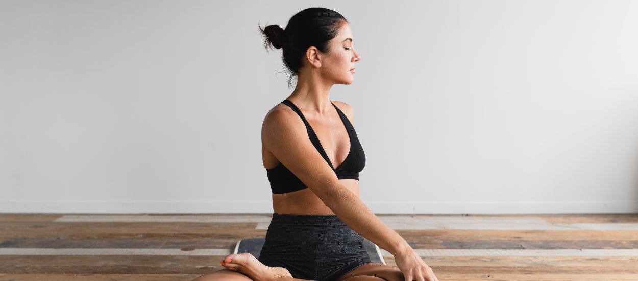 women twisting her back on yoga mat