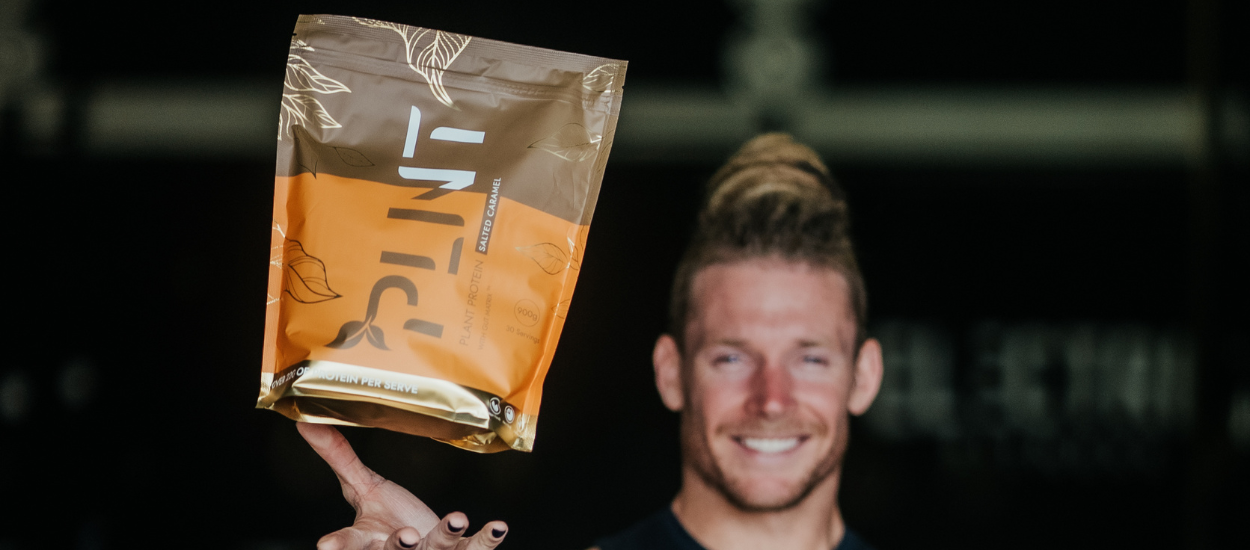 protein powder being held by crossfit athlete james newbury